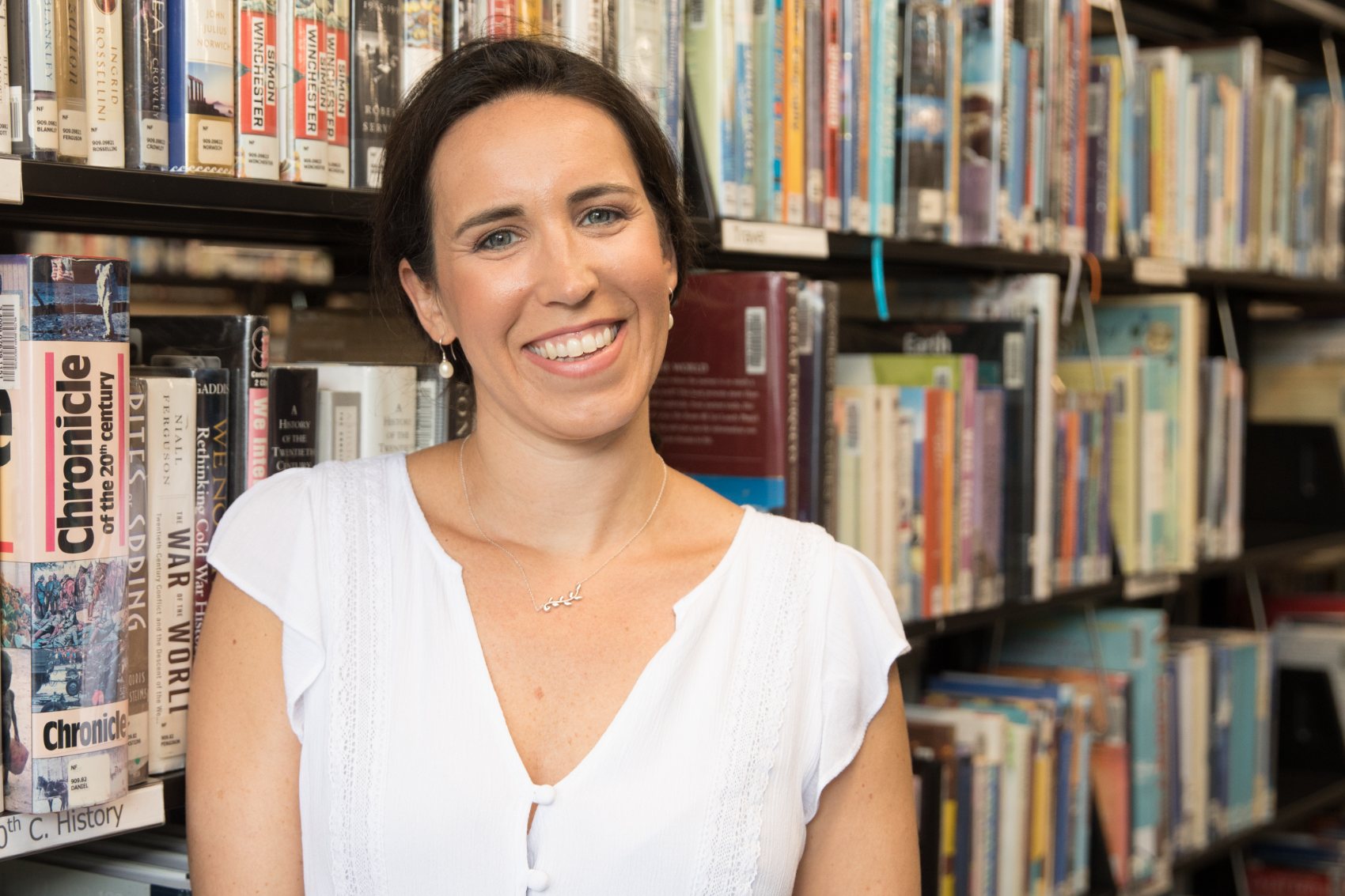 Katie Egan Cunningham in front of library bookshelves